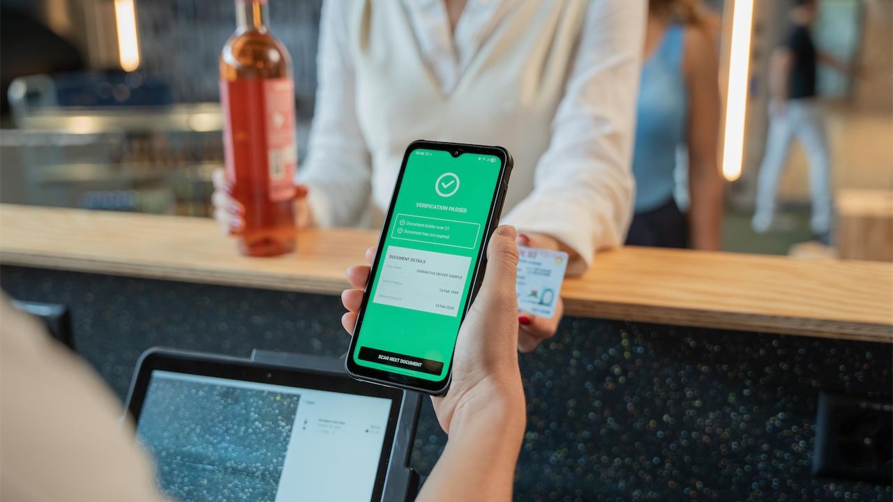 Cashier verifying customer's age before selling alcohol