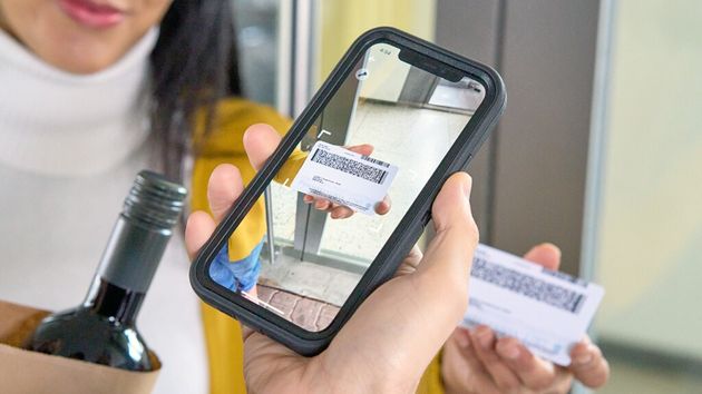 a delivery driver scanning a customer's id to verify age during an alcohol delivery